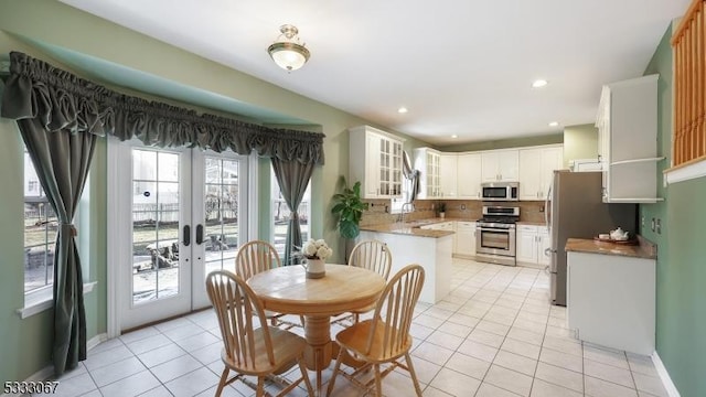 dining room featuring sink, french doors, and light tile patterned flooring