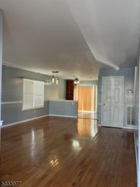 unfurnished living room featuring baseboards and wood finished floors