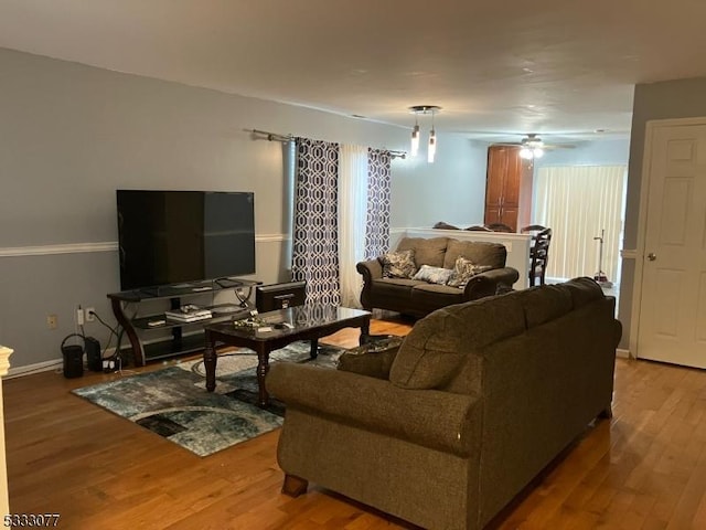 living room featuring wood-type flooring and ceiling fan