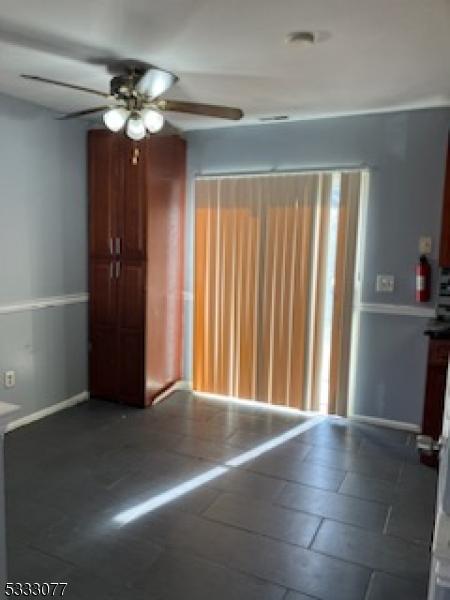 spare room with baseboards and a ceiling fan