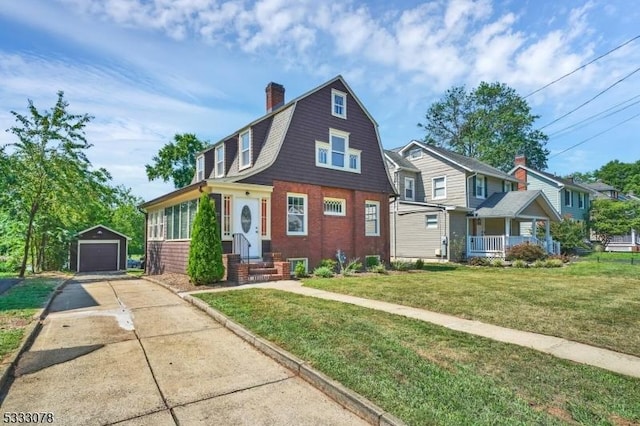 view of front facade featuring a garage, a front lawn, and an outbuilding