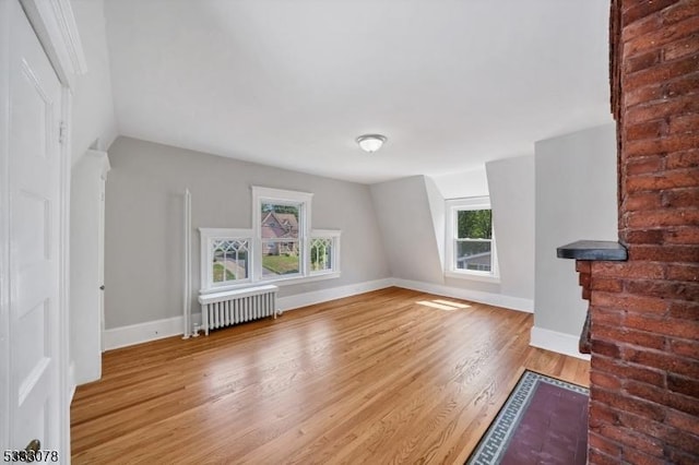 unfurnished living room with wood-type flooring and radiator heating unit