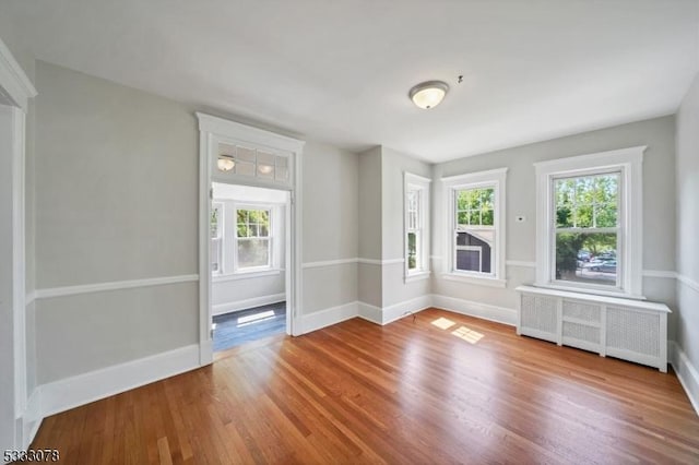 unfurnished living room with hardwood / wood-style flooring and radiator