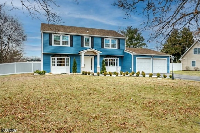 colonial-style house with a front yard and a garage