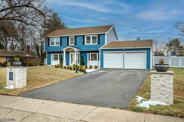 colonial house with a garage and a front lawn