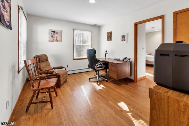 office space featuring a baseboard radiator and light hardwood / wood-style floors