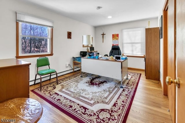 office space with baseboard heating, light hardwood / wood-style flooring, and plenty of natural light