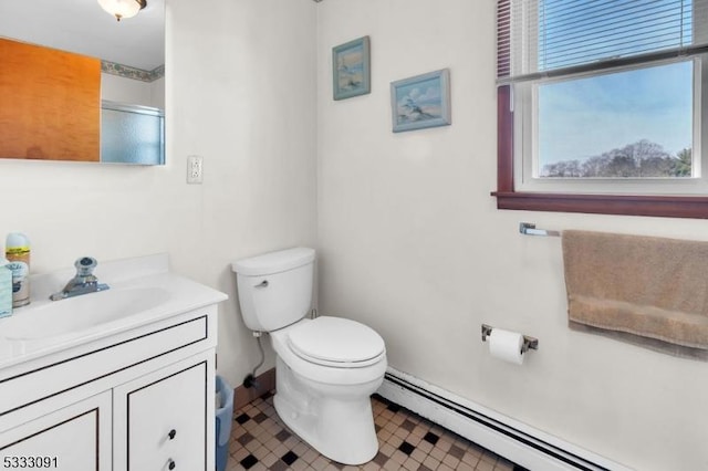 bathroom featuring toilet, a shower with door, vanity, and a baseboard radiator