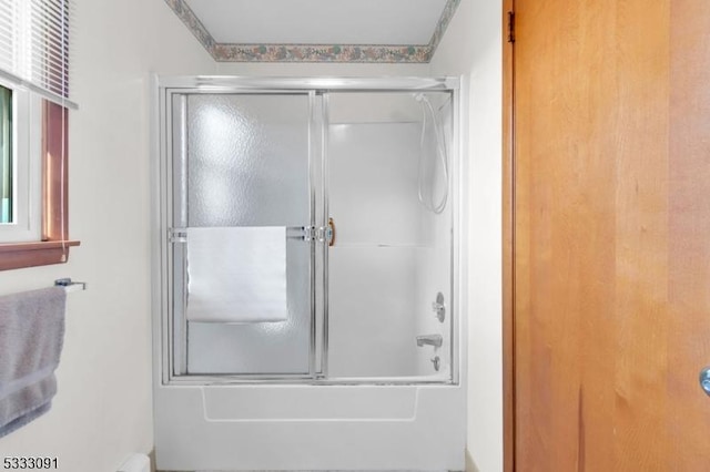 bathroom featuring combined bath / shower with glass door