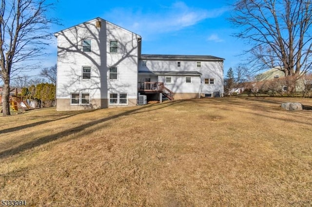 back of house featuring a wooden deck, cooling unit, and a lawn