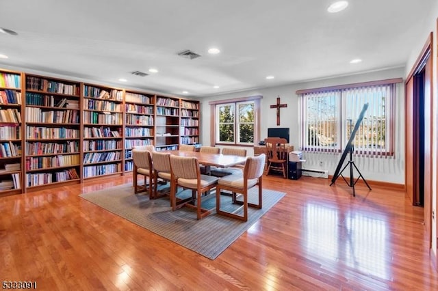 dining area with baseboard heating and light hardwood / wood-style flooring