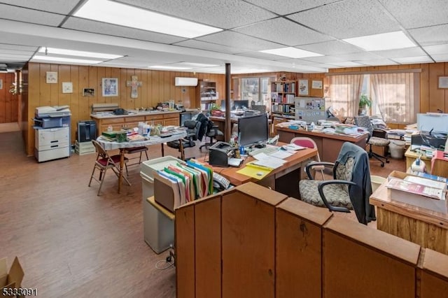 home office featuring a drop ceiling and wooden walls