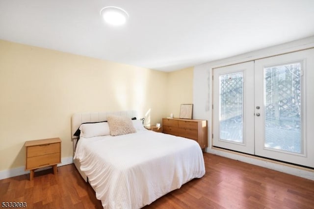 bedroom with access to outside, french doors, and dark wood-type flooring