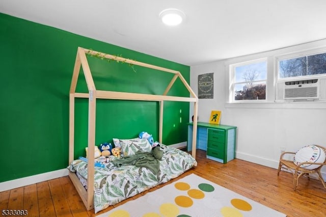 bedroom featuring hardwood / wood-style floors and cooling unit