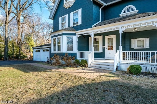 view of front facade featuring a front lawn, covered porch, and a garage