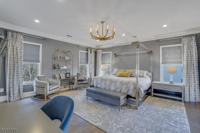 bedroom with crown molding, hardwood / wood-style floors, and an inviting chandelier