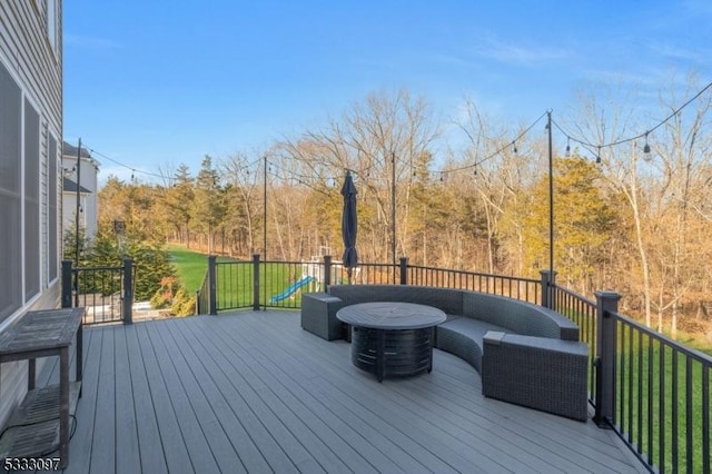 deck with an outdoor living space and a playground