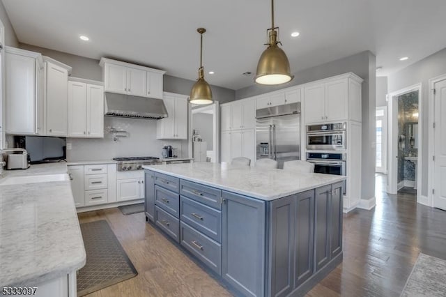 kitchen featuring decorative light fixtures, light stone counters, white cabinetry, and stainless steel appliances