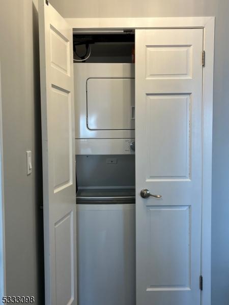 laundry room featuring stacked washer / drying machine