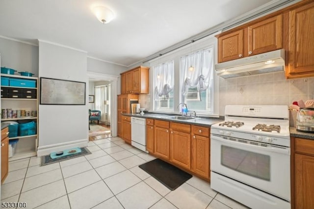 kitchen with tasteful backsplash, sink, white appliances, and light tile patterned floors