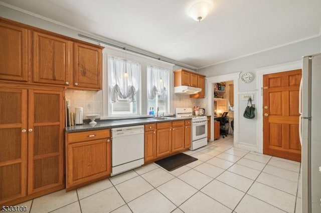 kitchen with tasteful backsplash, light tile patterned flooring, sink, and white appliances