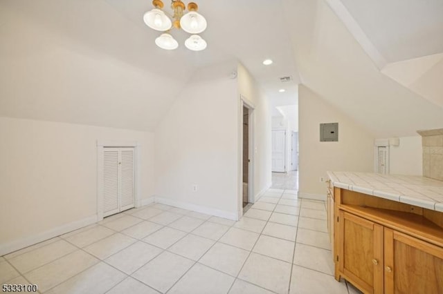 bathroom featuring lofted ceiling, tile patterned floors, and an inviting chandelier