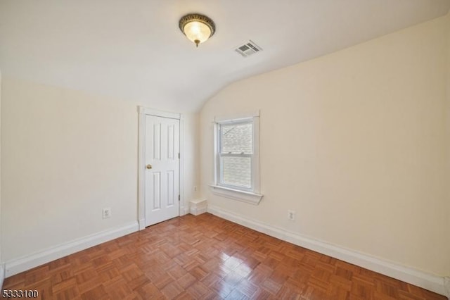 spare room with lofted ceiling and parquet flooring