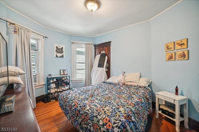 bedroom featuring ornamental molding and dark hardwood / wood-style flooring