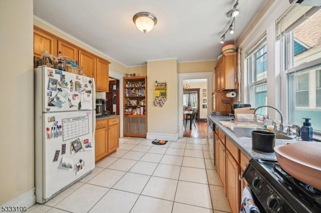 kitchen with white refrigerator, crown molding, gas stove, and light tile patterned floors