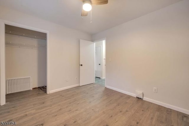 unfurnished bedroom featuring ceiling fan, a closet, and light hardwood / wood-style flooring