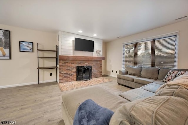 living room with light hardwood / wood-style floors and a fireplace