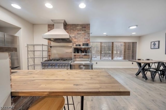 kitchen with stove, hardwood / wood-style flooring, and custom range hood