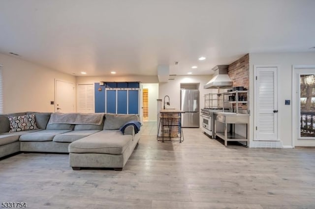 living room featuring sink and light hardwood / wood-style floors