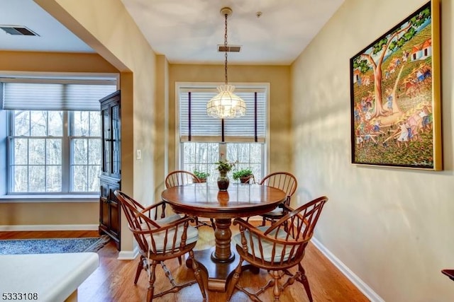 dining room with wood-type flooring and a notable chandelier