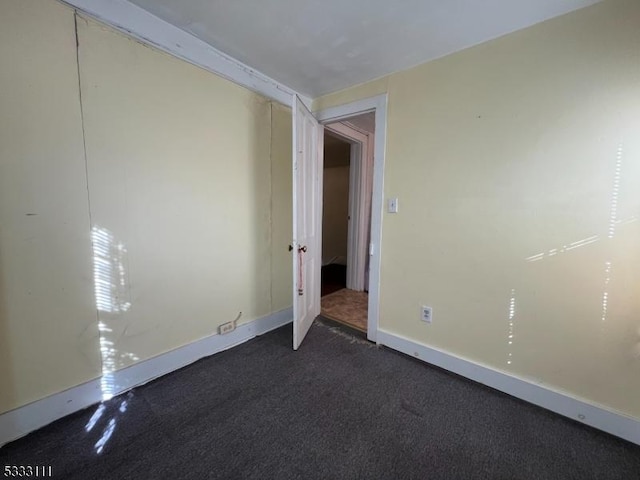 empty room with dark colored carpet