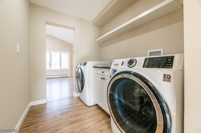 clothes washing area with light wood-type flooring, baseboard heating, washing machine and dryer, and cabinets