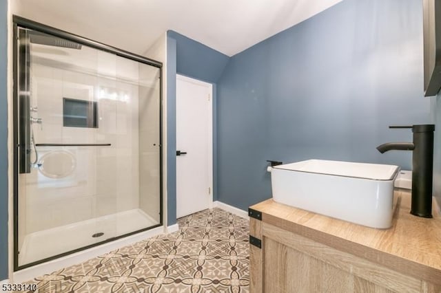 bathroom featuring walk in shower, tile patterned flooring, and sink