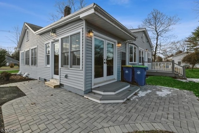 view of side of home with a patio area, a deck, and french doors