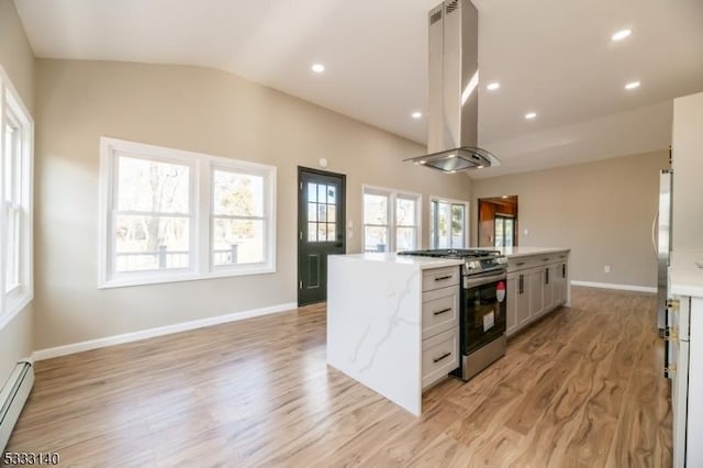 kitchen featuring vaulted ceiling, island exhaust hood, appliances with stainless steel finishes, white cabinets, and a baseboard radiator