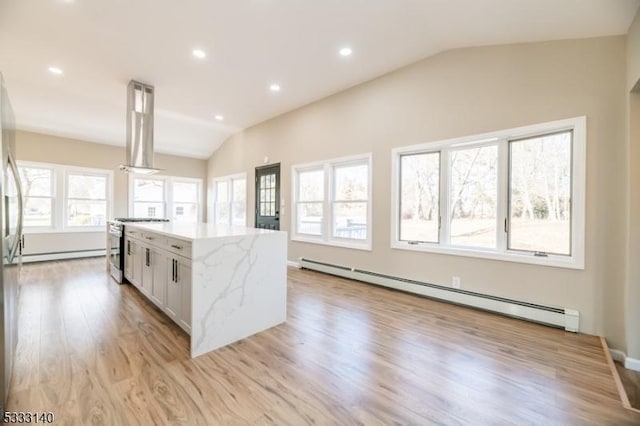 kitchen with a baseboard radiator, white cabinets, island exhaust hood, and lofted ceiling