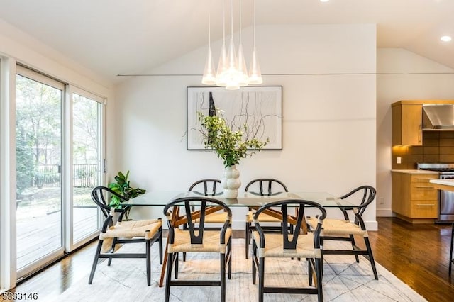 dining space featuring lofted ceiling and light wood-type flooring