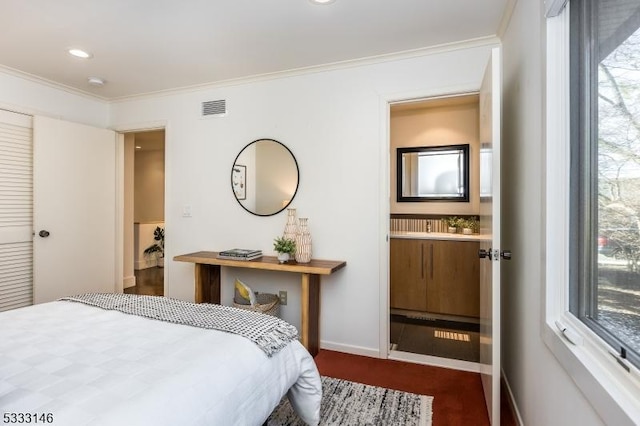 bedroom featuring connected bathroom and ornamental molding