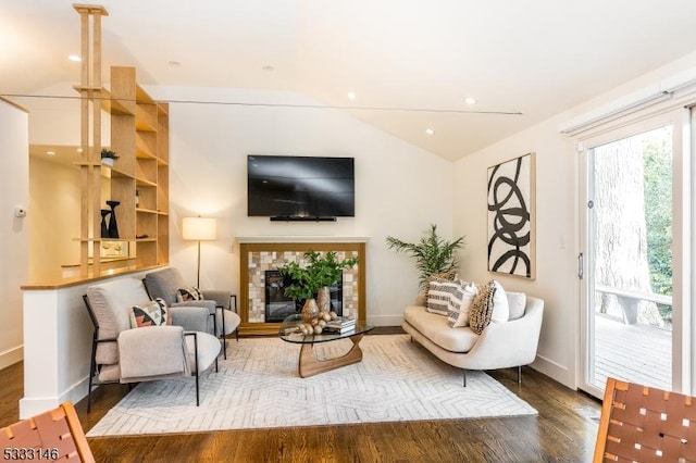 living room featuring lofted ceiling, a fireplace, and dark hardwood / wood-style floors