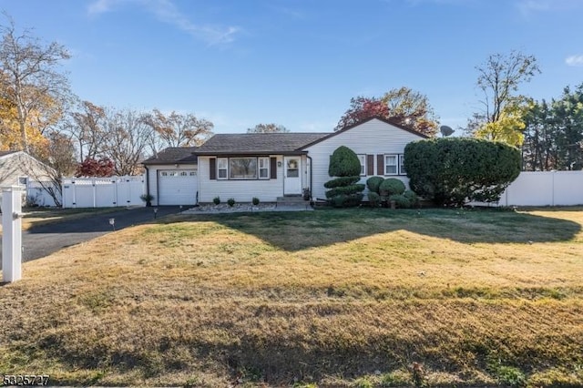 ranch-style house featuring a garage and a front lawn