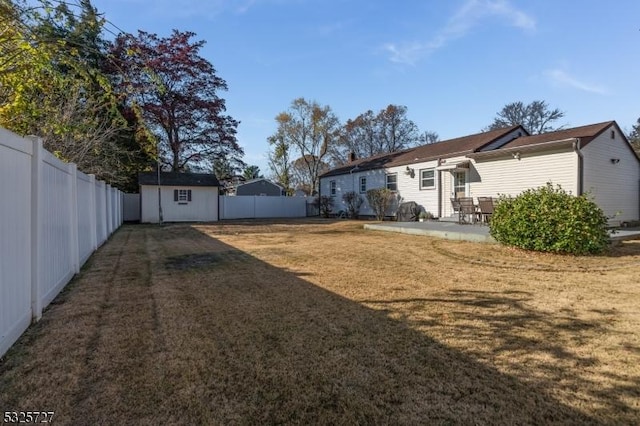 view of yard featuring a storage shed and a patio