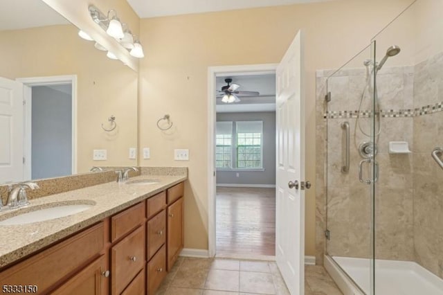 bathroom featuring ceiling fan, tile patterned flooring, an enclosed shower, and vanity