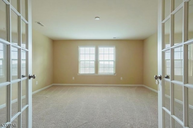 carpeted spare room with french doors