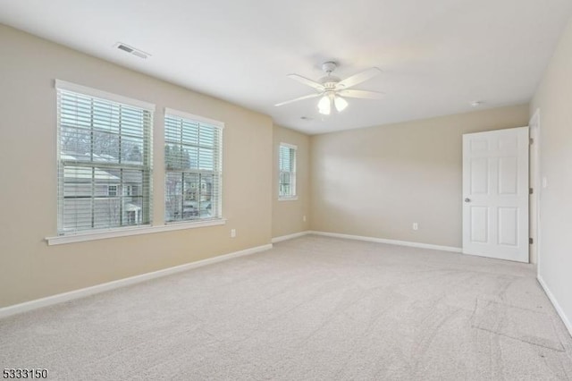 carpeted spare room with ceiling fan