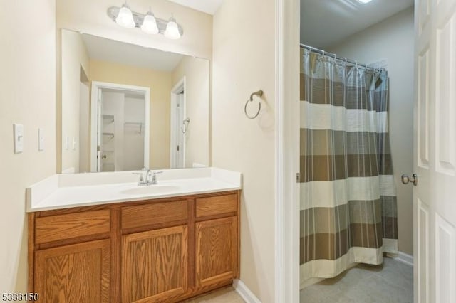 bathroom featuring walk in shower and vanity