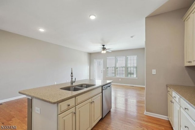 kitchen featuring ceiling fan, stainless steel dishwasher, sink, an island with sink, and cream cabinets